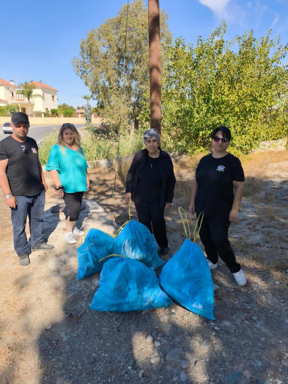Φωτογραφία με τρείς γυναίκες και ένα άνδρα με τα σκυβαλοσάκουλα τους.